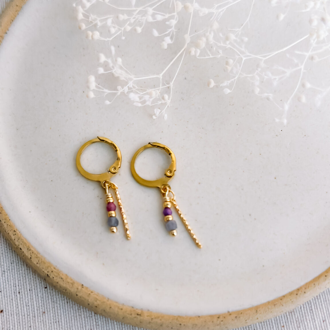 Isa & Roza : oorbellen met twinkelend staafje en paars en blauwgrijs steentje.